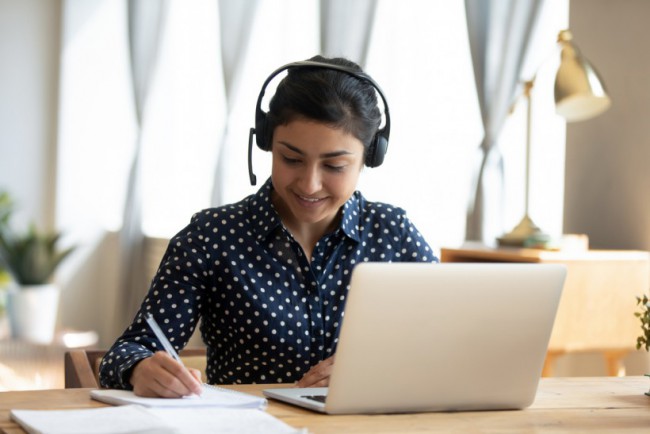 Indian girl student wear headset study online teacher write notes BDE 30 hours of online portion only - Master Driving School - Master Drivers - Kitchener Waterloo - MTO approved online beginner driver education